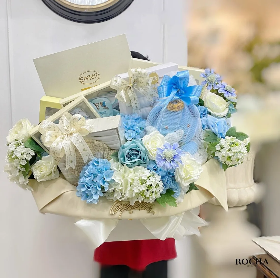 Newborn gift basket with blue and white flowers and wrapped presents