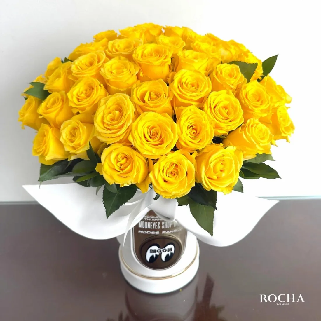 A dome of yellow roses arranged in an ivory hat-box
